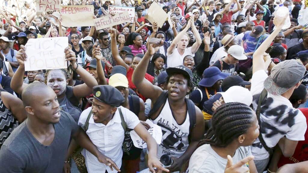 Quand la jeunesse africaine se lève : des étudiants manifestent devant le Parlement sud-africain, au Cap, le 21 octobre 2015, contre la hausse des frais d’inscription (mouvement #FeesMustFall). Source : RFI.
